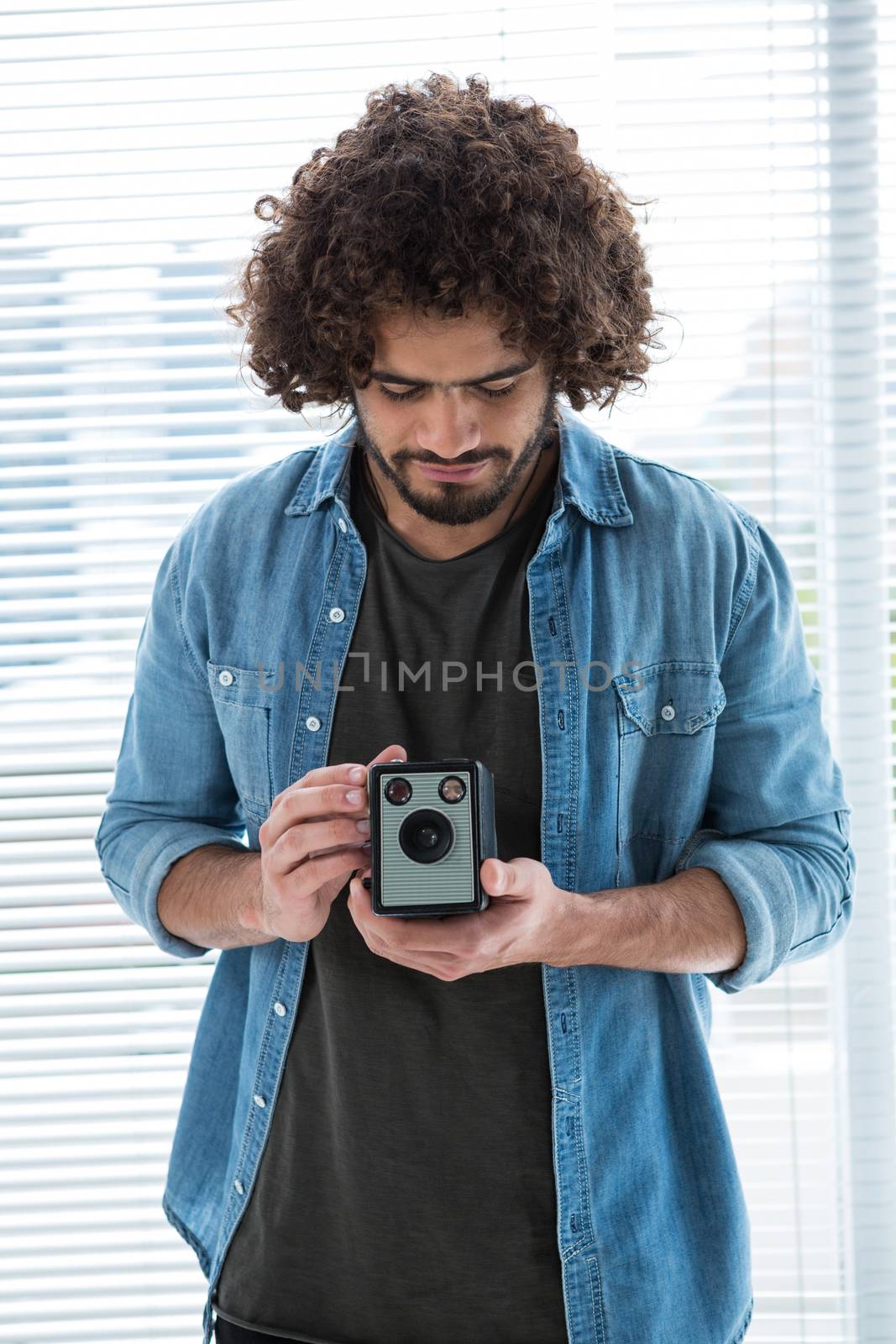 Male photographer with old fashioned camera in studio