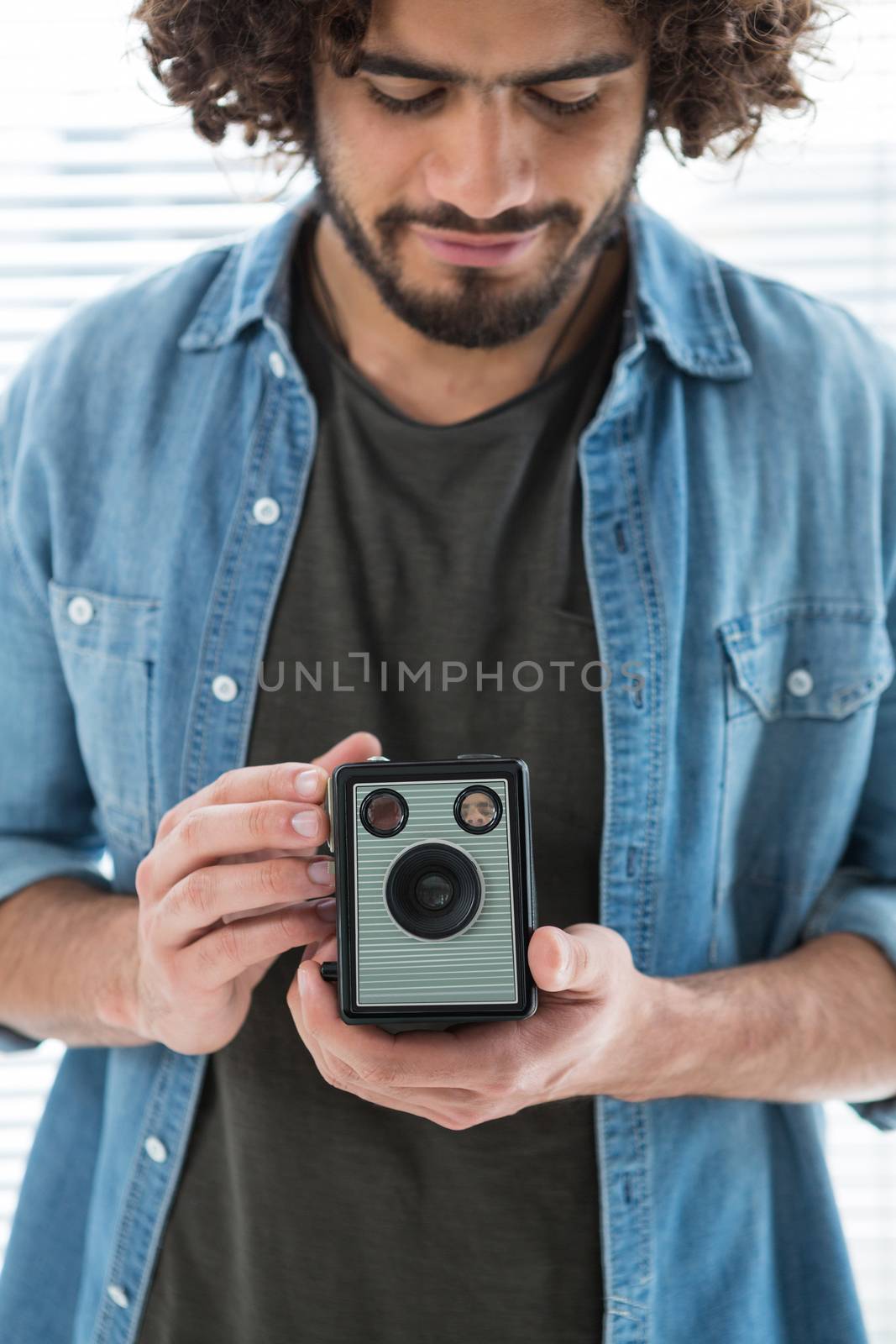 Male photographer with old fashioned camera in studio