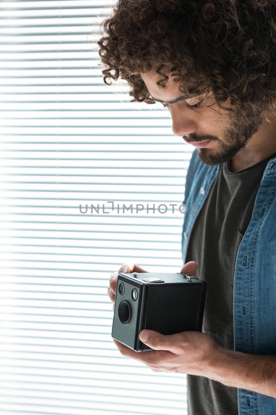 Male photographer with old fashioned camera in studio