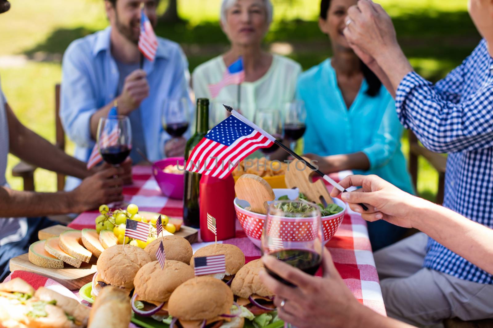 Happy family having meal on table in park