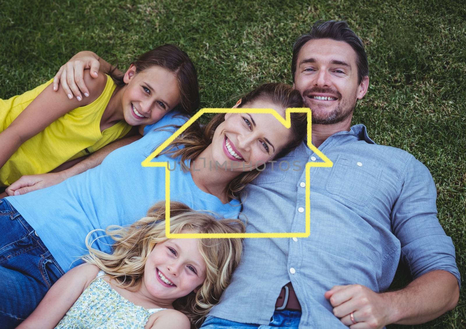 Happy family lying on grass with digitally generated house outline