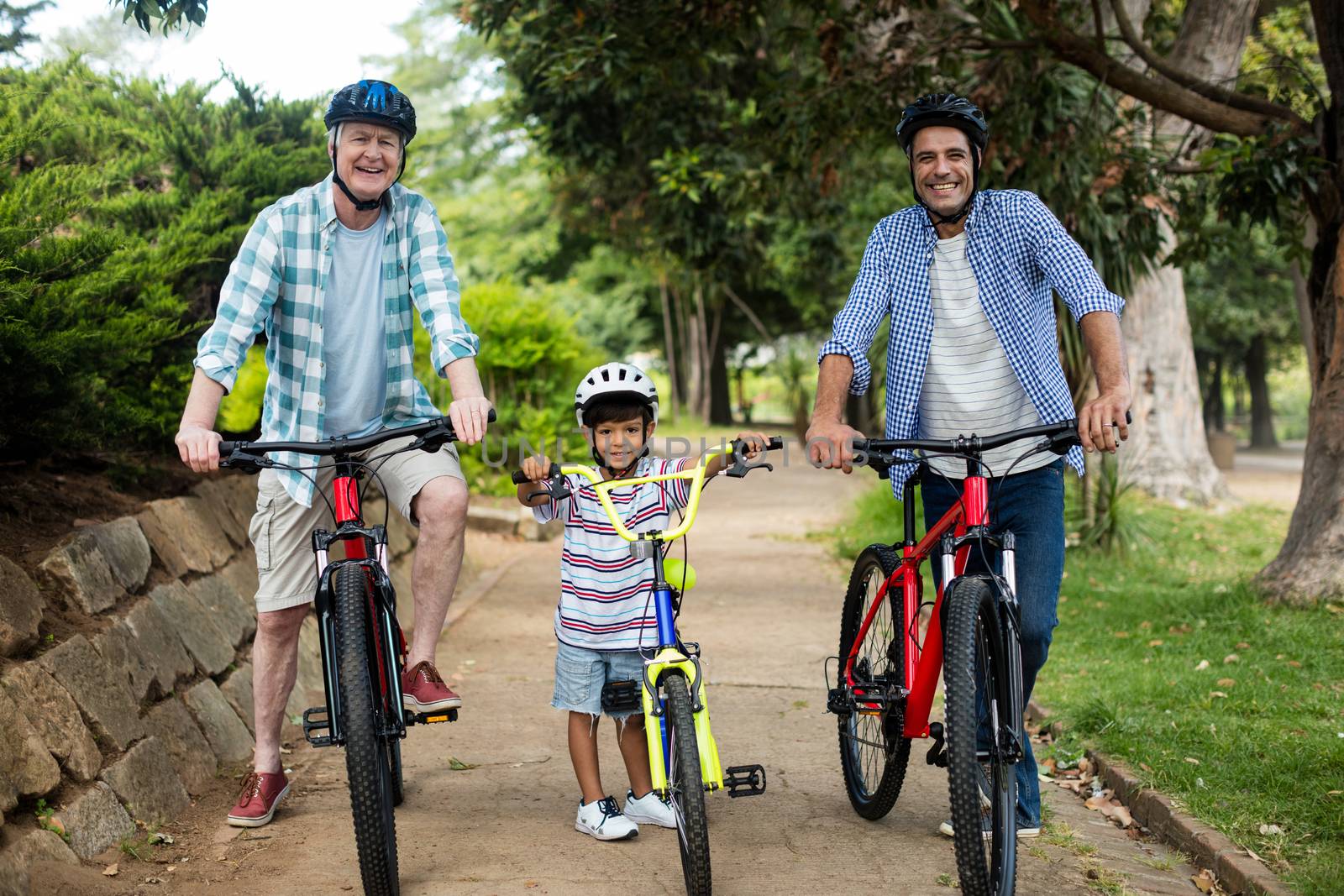 Happy family cycling in park by Wavebreakmedia