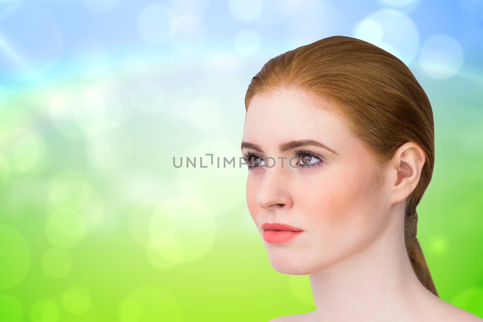 Beautiful redhead posing with hair tied against green and blue abstract design