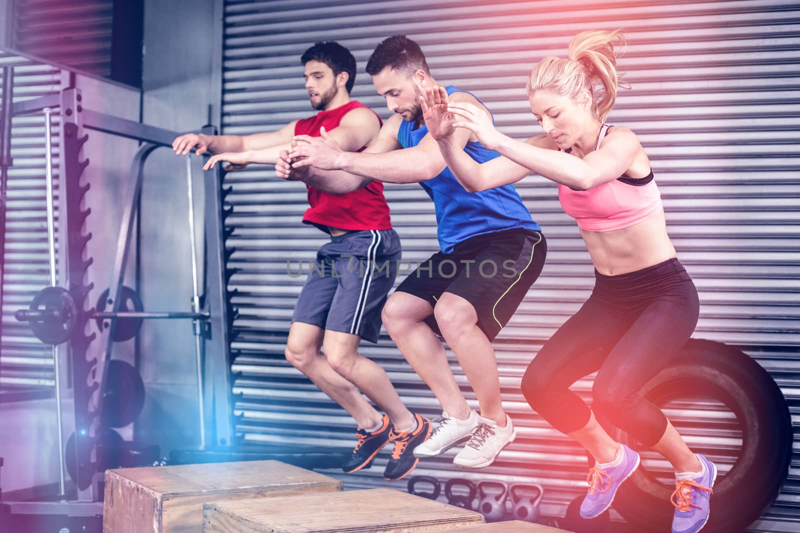 Fit people doing exercises with box at crossfit gym