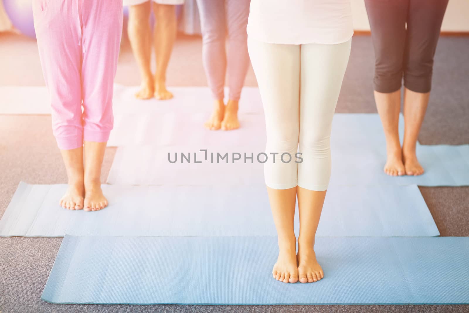 Low section of instructor performing yoga with seniors by Wavebreakmedia