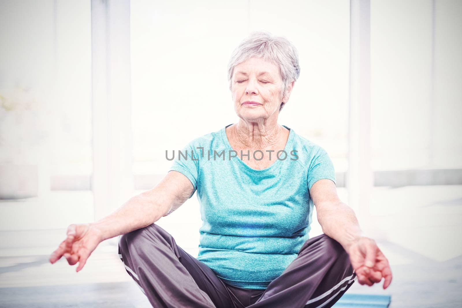 Senior woman performing yoga while sitting at home