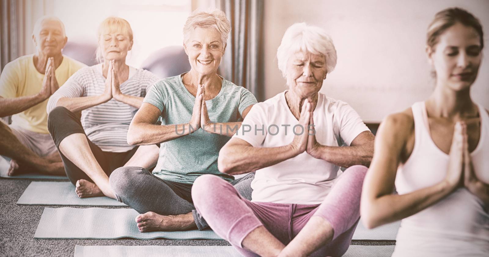Instructor performing yoga with seniors by Wavebreakmedia