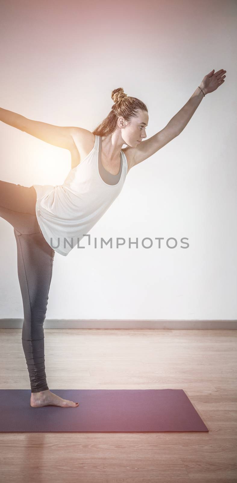 Woman in lord of dance yoga pose in fitness studio 