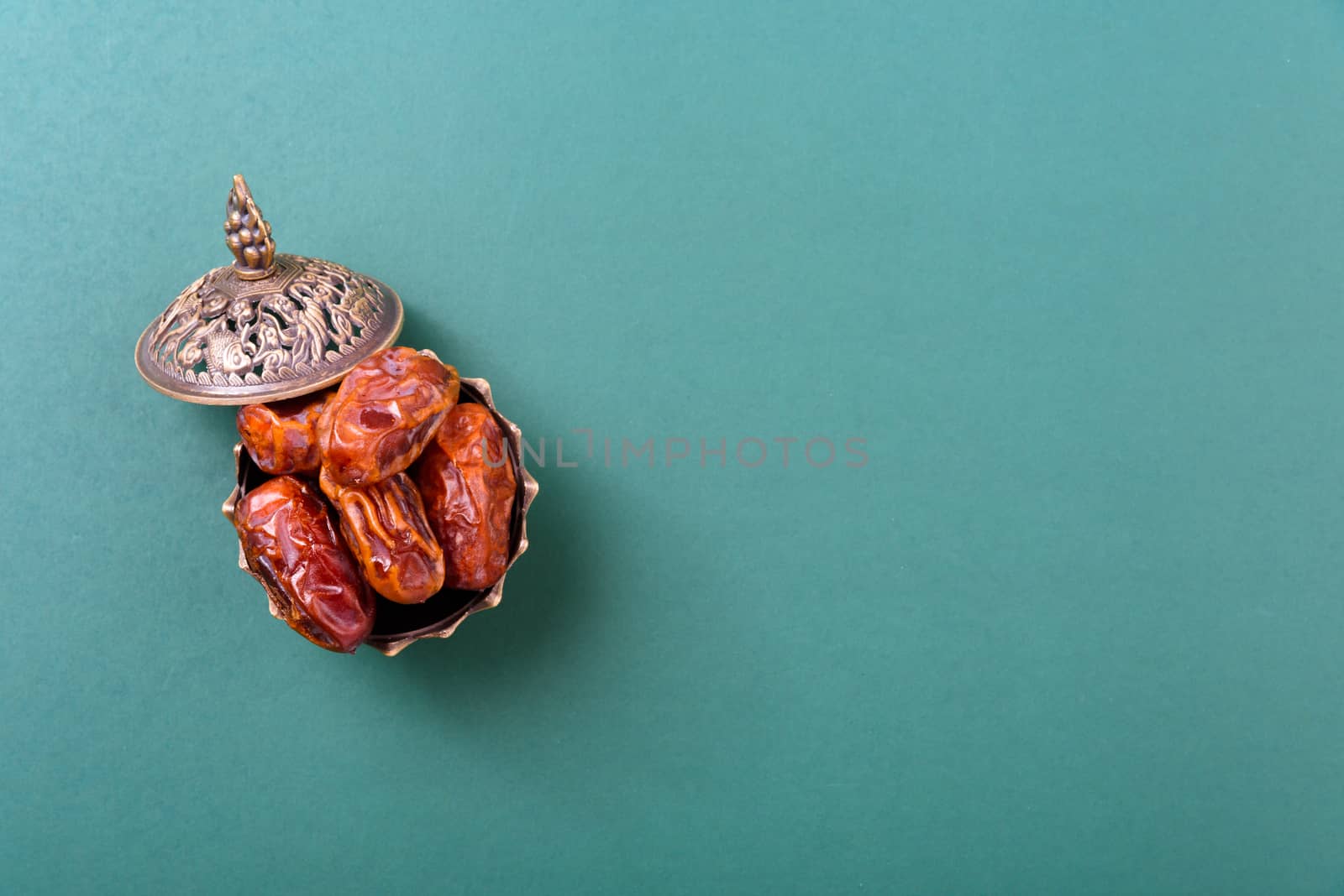 Ramadan, Dates in golden bowl and have arabian Aladdin golden lamp vintage style on black green background