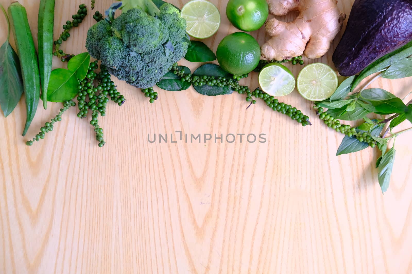 Fresh ripe green vegetables broccoli, ginger, lime, avocado, green pepper, Green okra and basil leaves on wooden background.  Organic vegetarian food ingredients vegetables  close up.