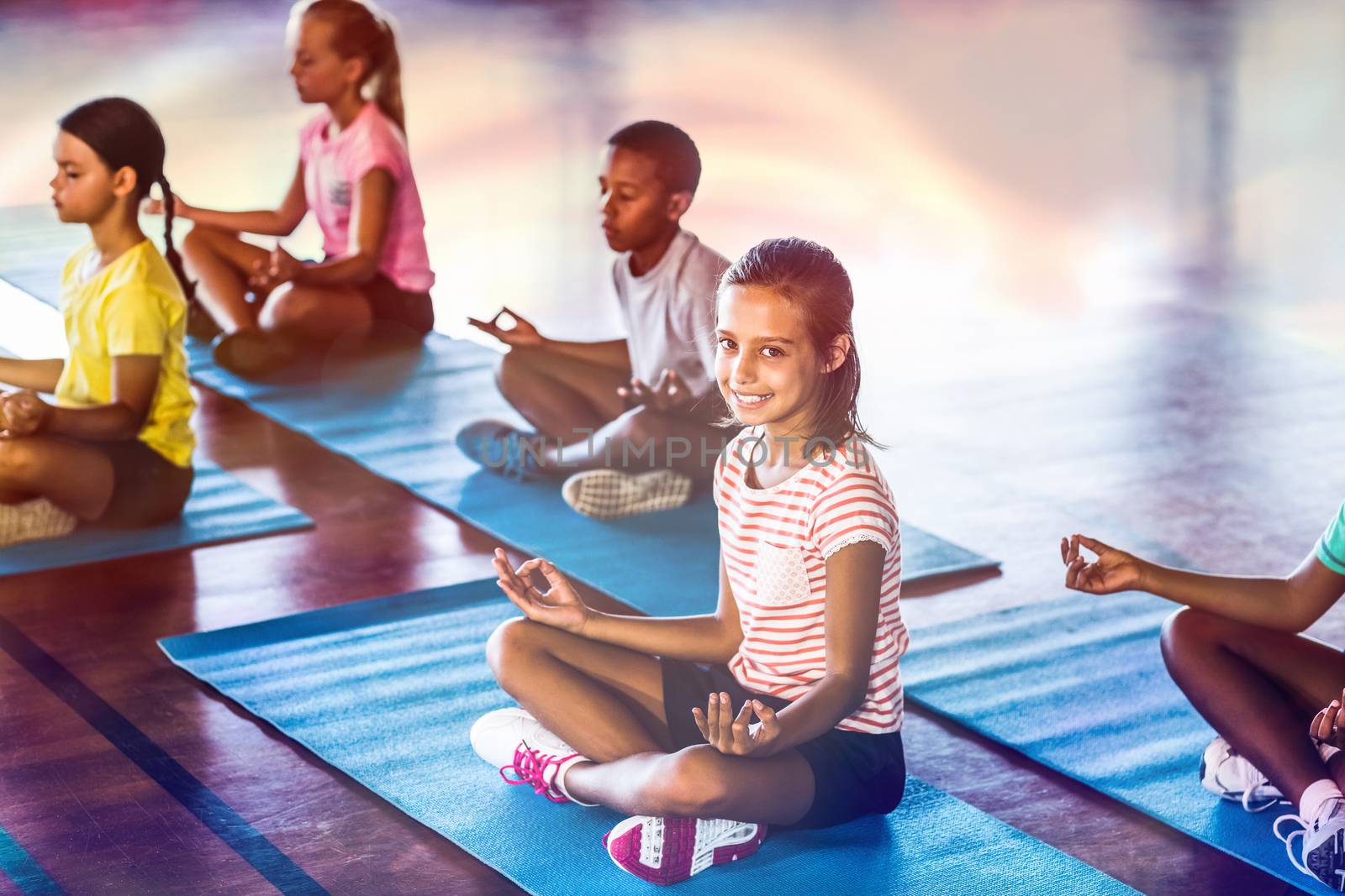 School kids meditating during yoga class by Wavebreakmedia