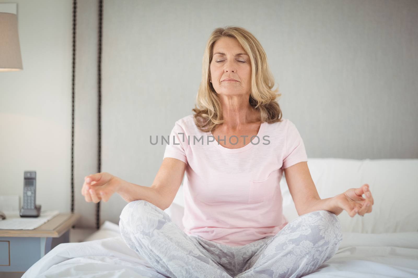 Senior practicing yoga on bed by Wavebreakmedia