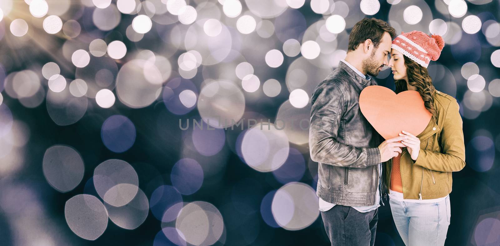 Composite image of romantic young couple holding heart shape paper by Wavebreakmedia
