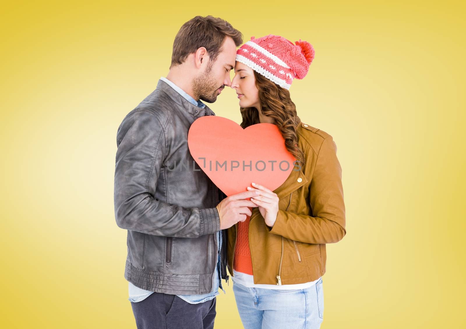 Romantic couple holding a heart against yellow background