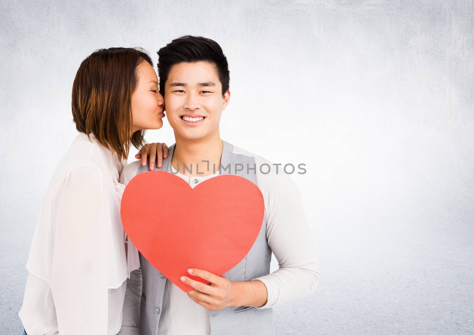 Romantic couple holding heart shape, woman kissing man