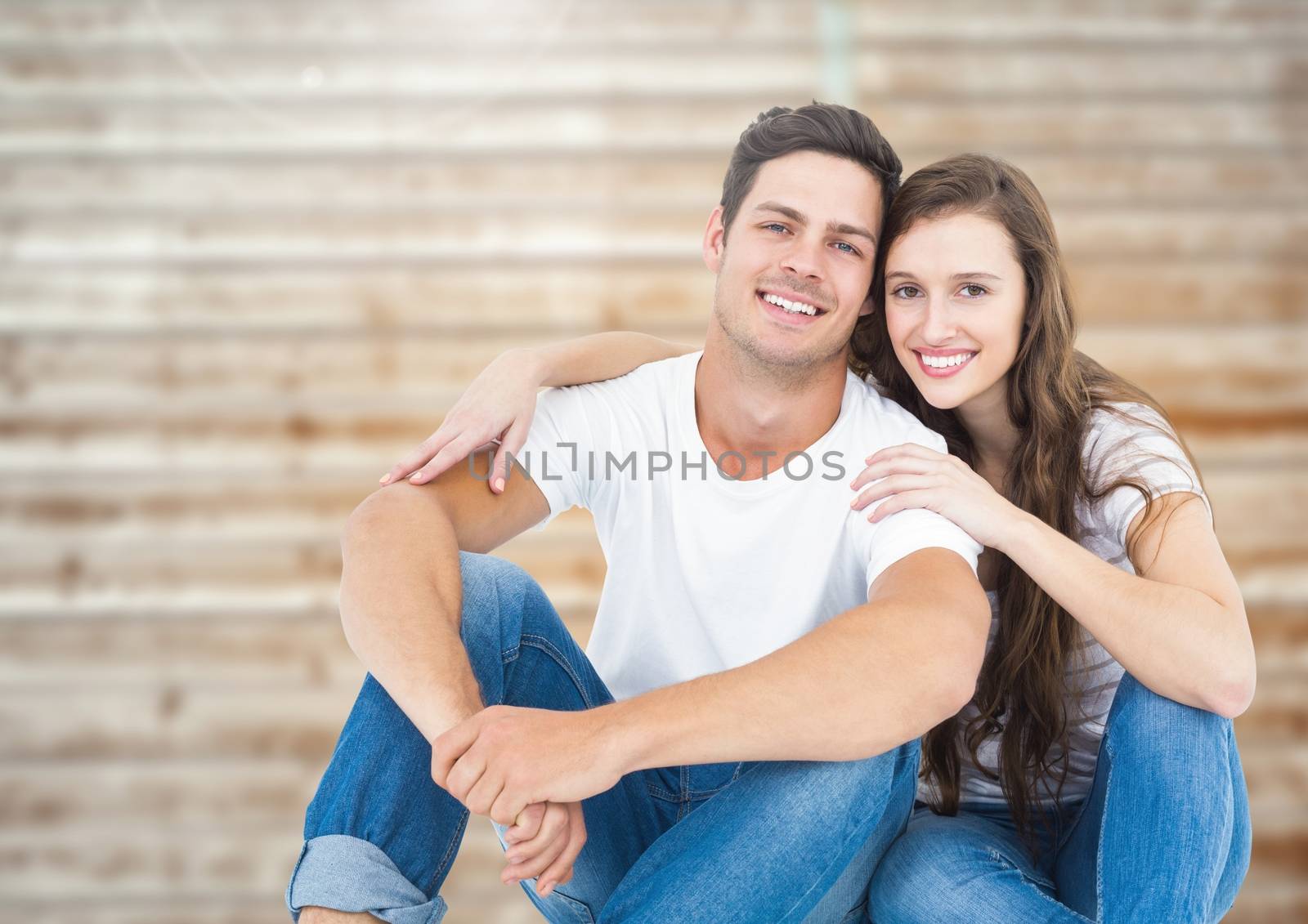 Romantic couple smiling and relaxing against wooden background