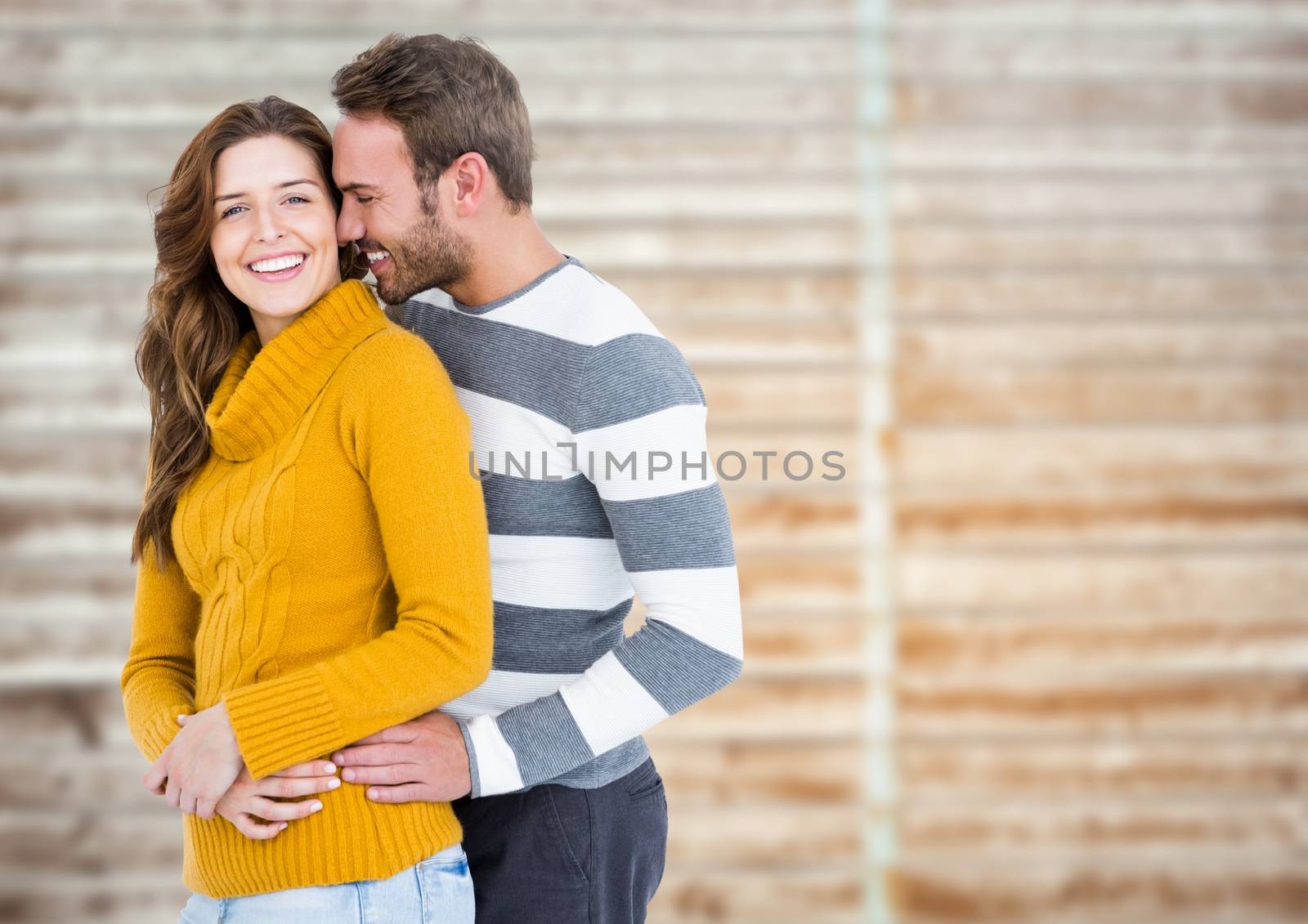 Romantic couple cuddling each other against wooden background