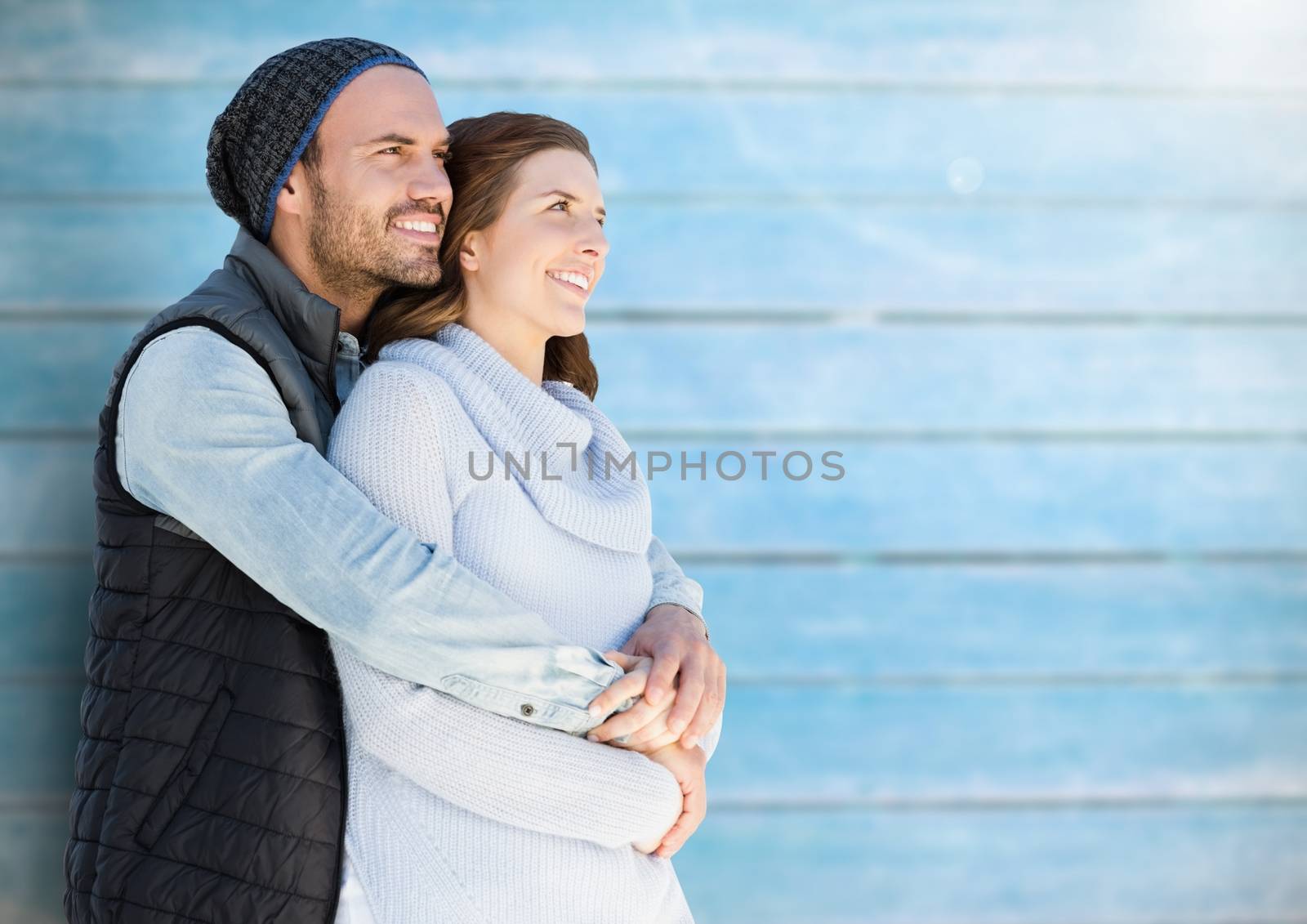 Romantic couple embracing each other against blue wooden background