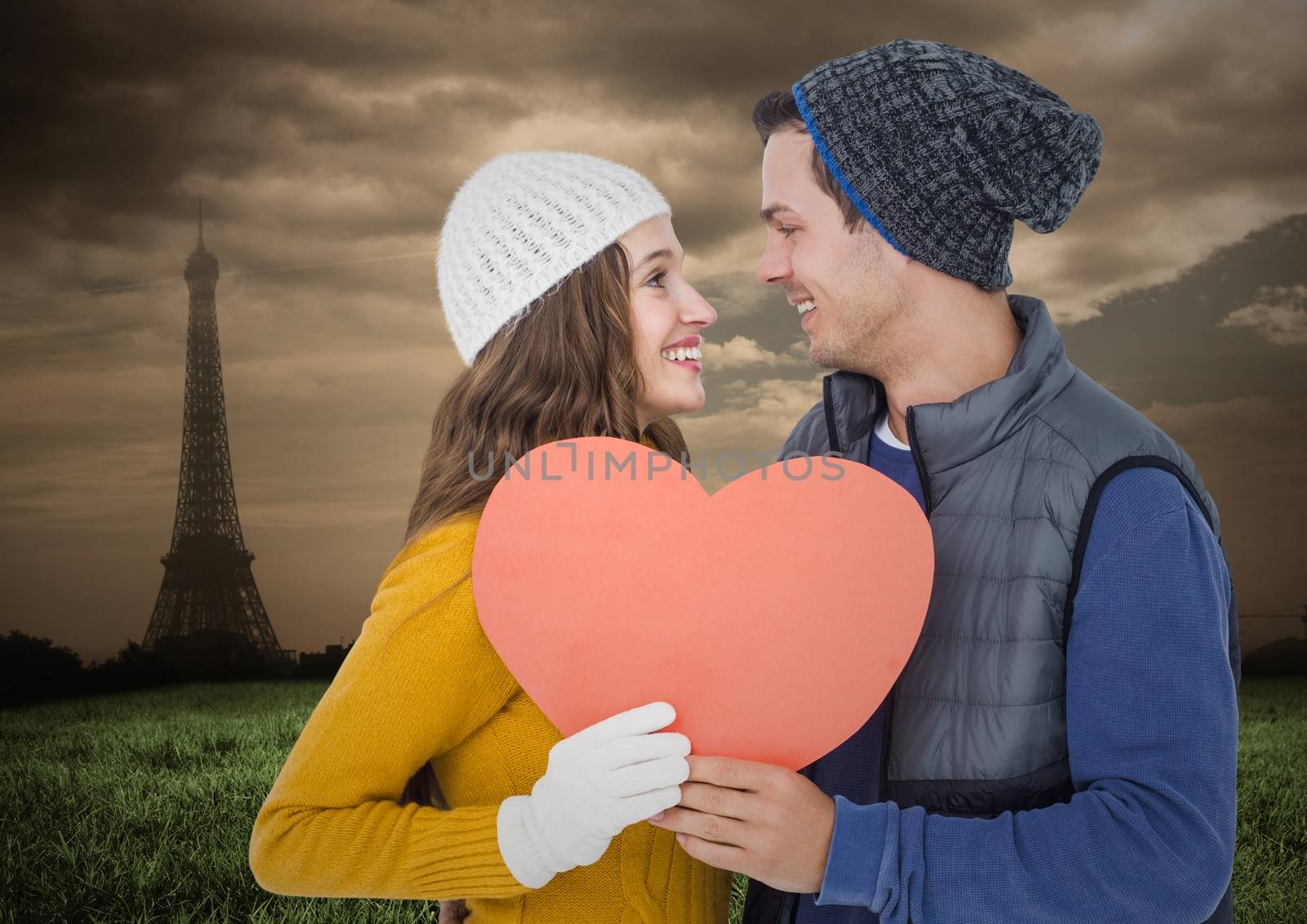 Romantic couple holding a heart against digitally generated background