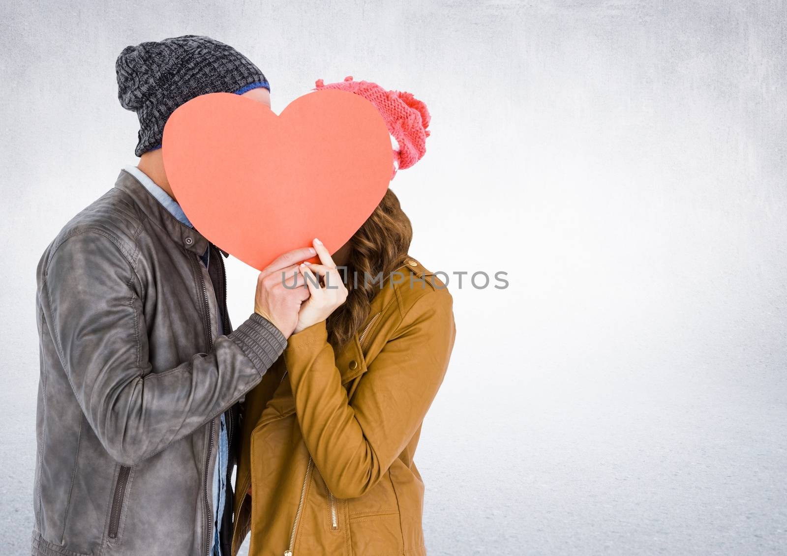 Romantic couple holding heart shape and kissing each other against white background