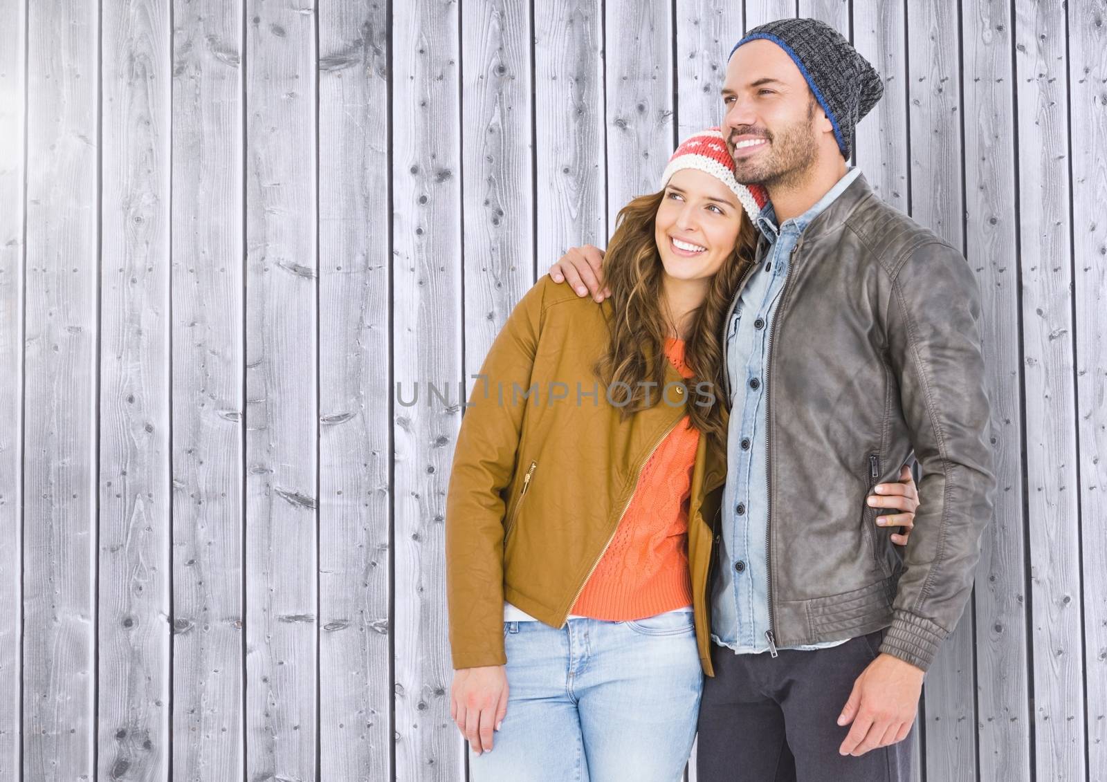 Romantic couple standing against wooden background