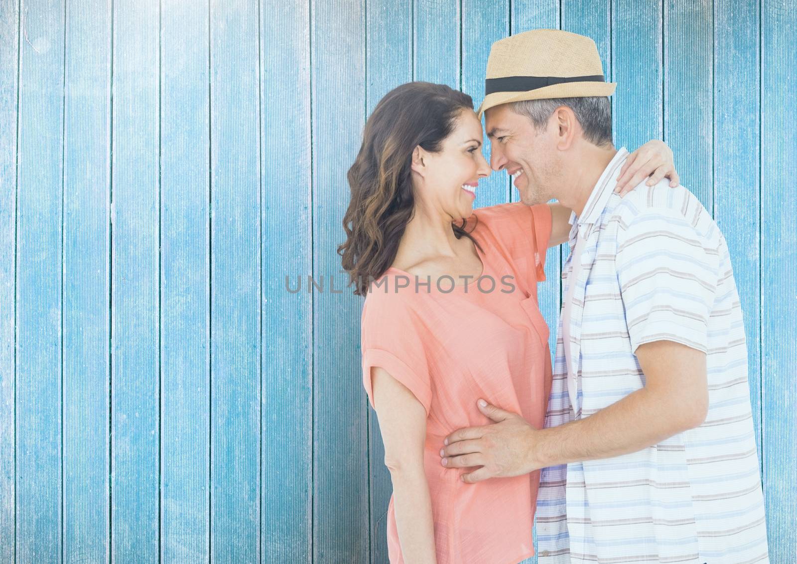 Romantic couple standing against blue wooden background