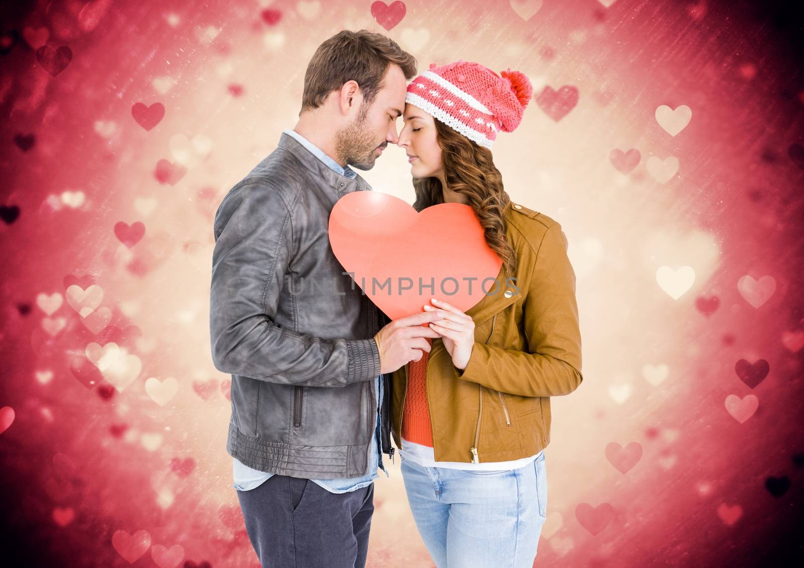 Composite image of romantic couple holding a heart