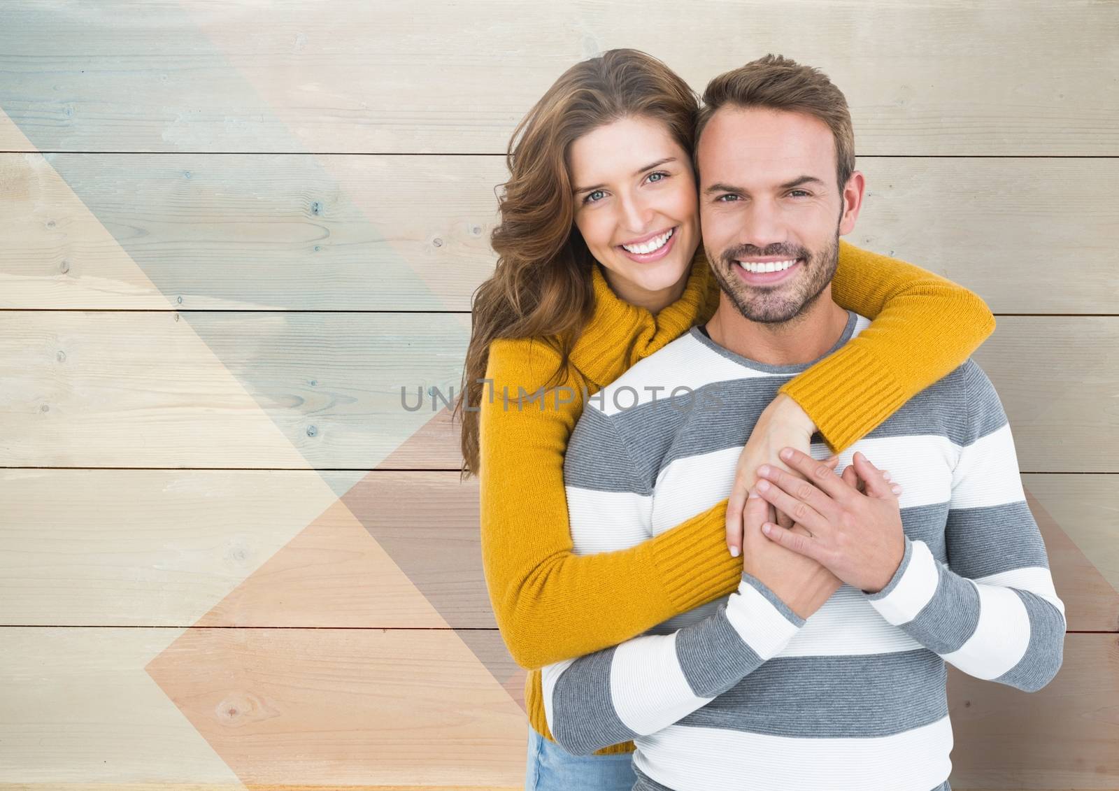 Portrait of romantic couple embracing each other against wooden background