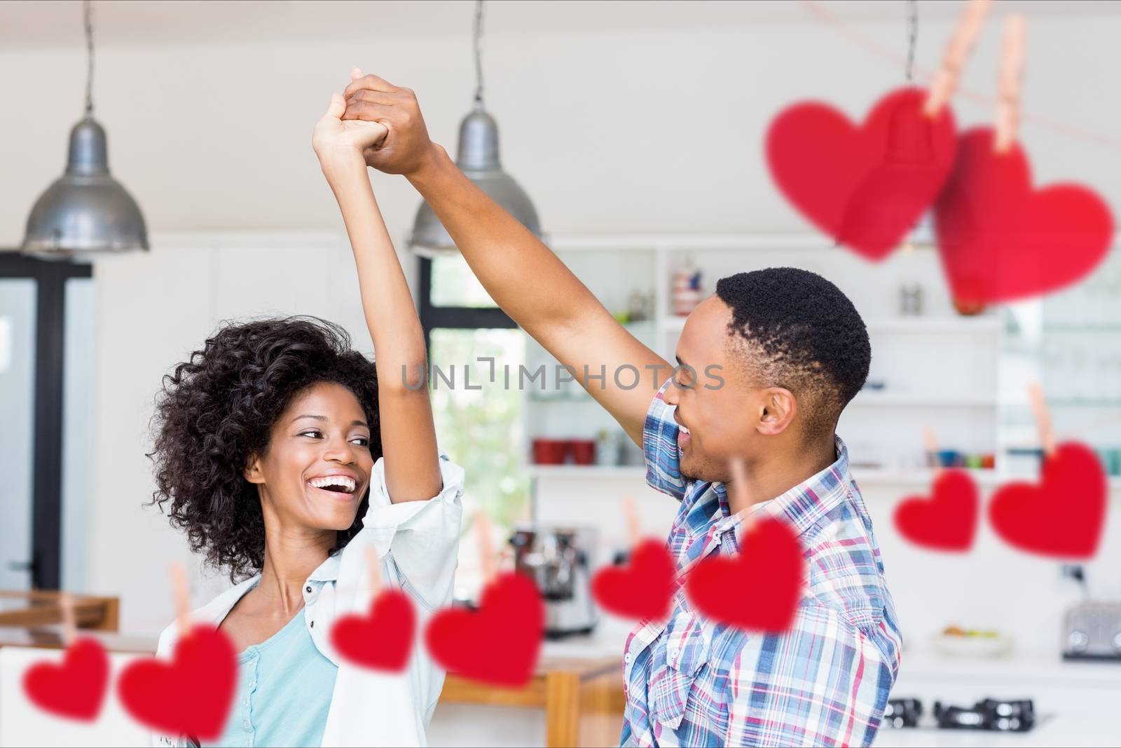 Romantic couple dancing against hanging red hearts