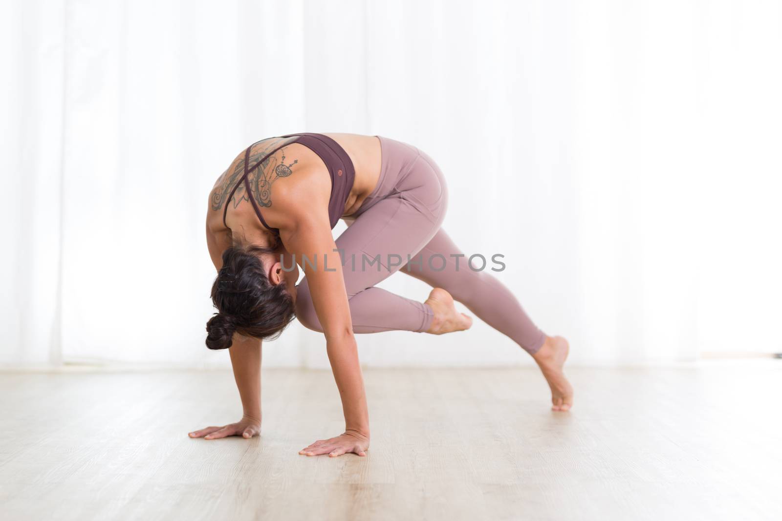 Portrait of gorgeous active sporty young woman practicing yoga in studio. Beautiful girl practice Sasangasana, rabbit yoga pose. Healthy active lifestyle, working out indoors in gym by kasto