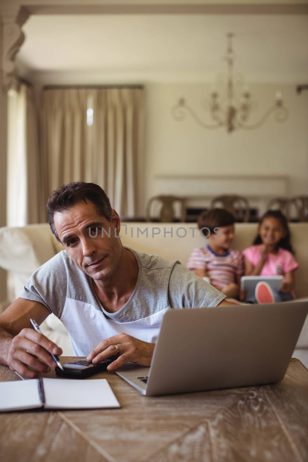 Man with laptop sitting in living room at home