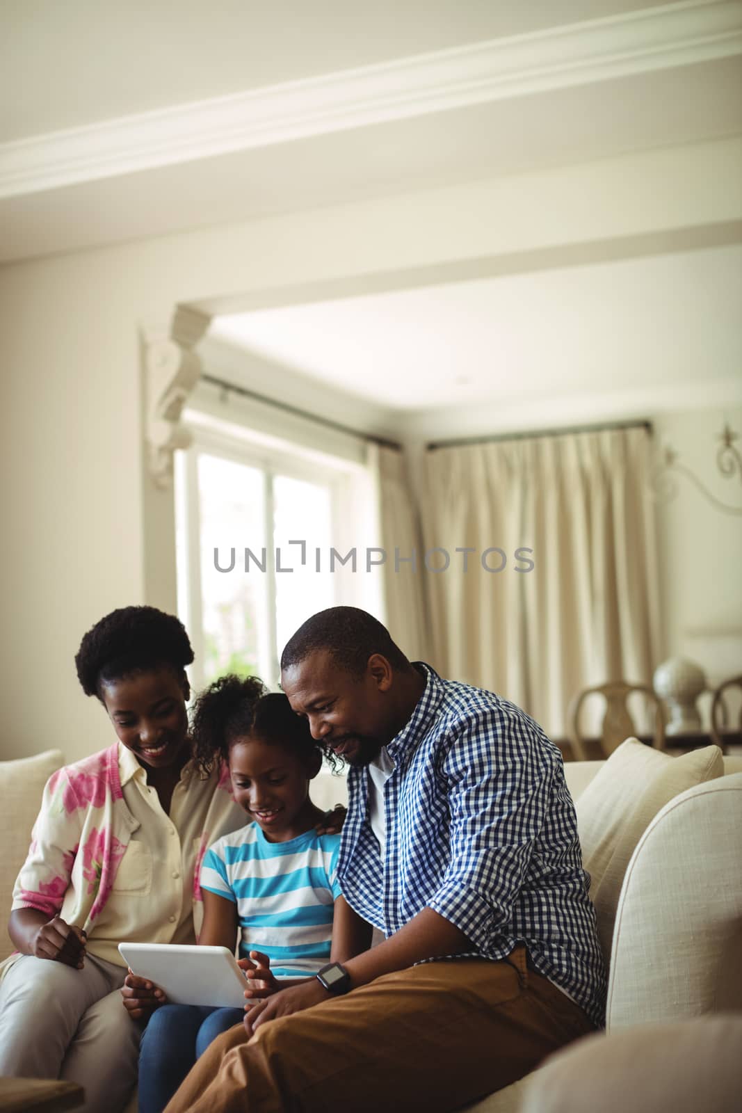 Family using digital tablet in living room at home