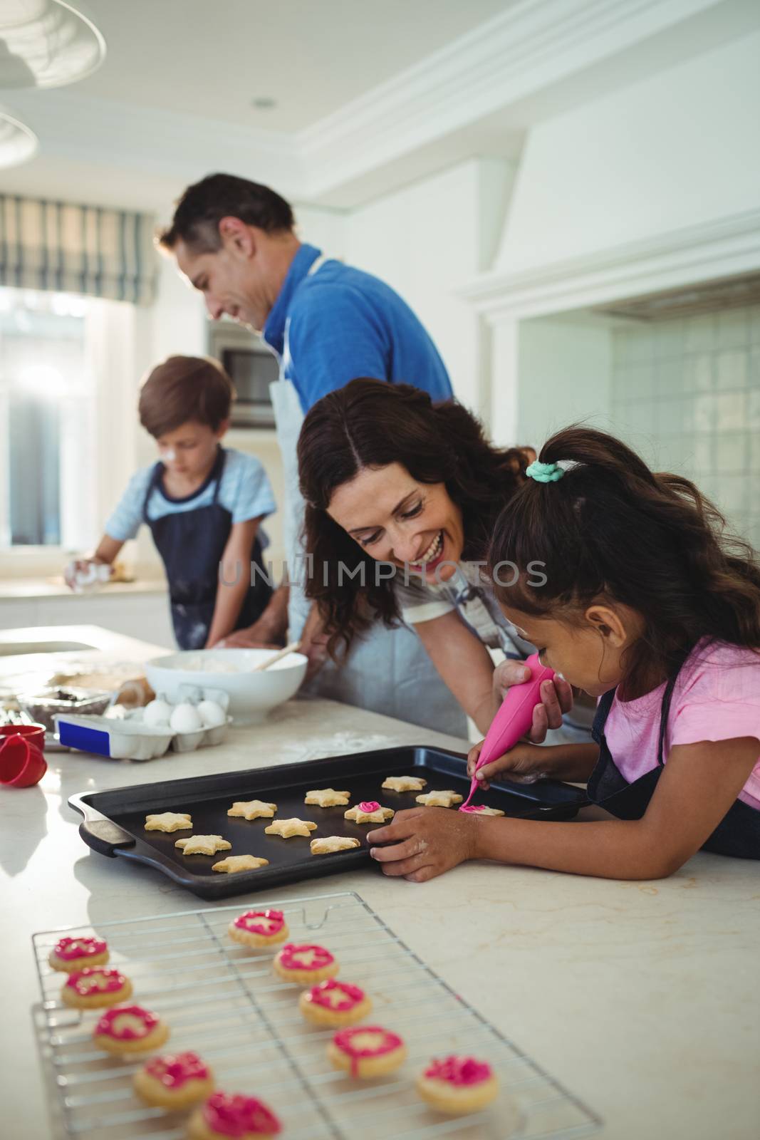 Happy family preparing cookies in kitchen at home