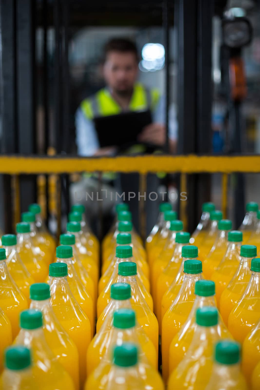 Close-up of juice bottles arranged in rows at factory