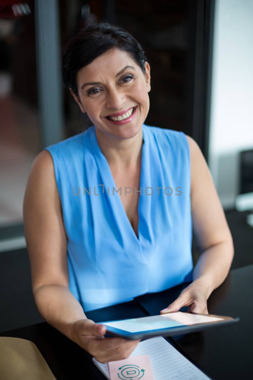 Portrait of smiling business executive using digital tablet in office