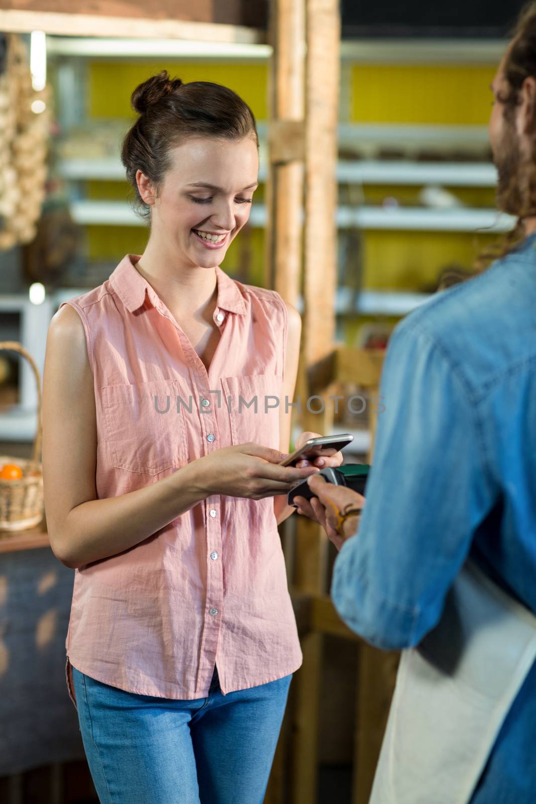 Woman making a payment by using NFC technology by Wavebreakmedia