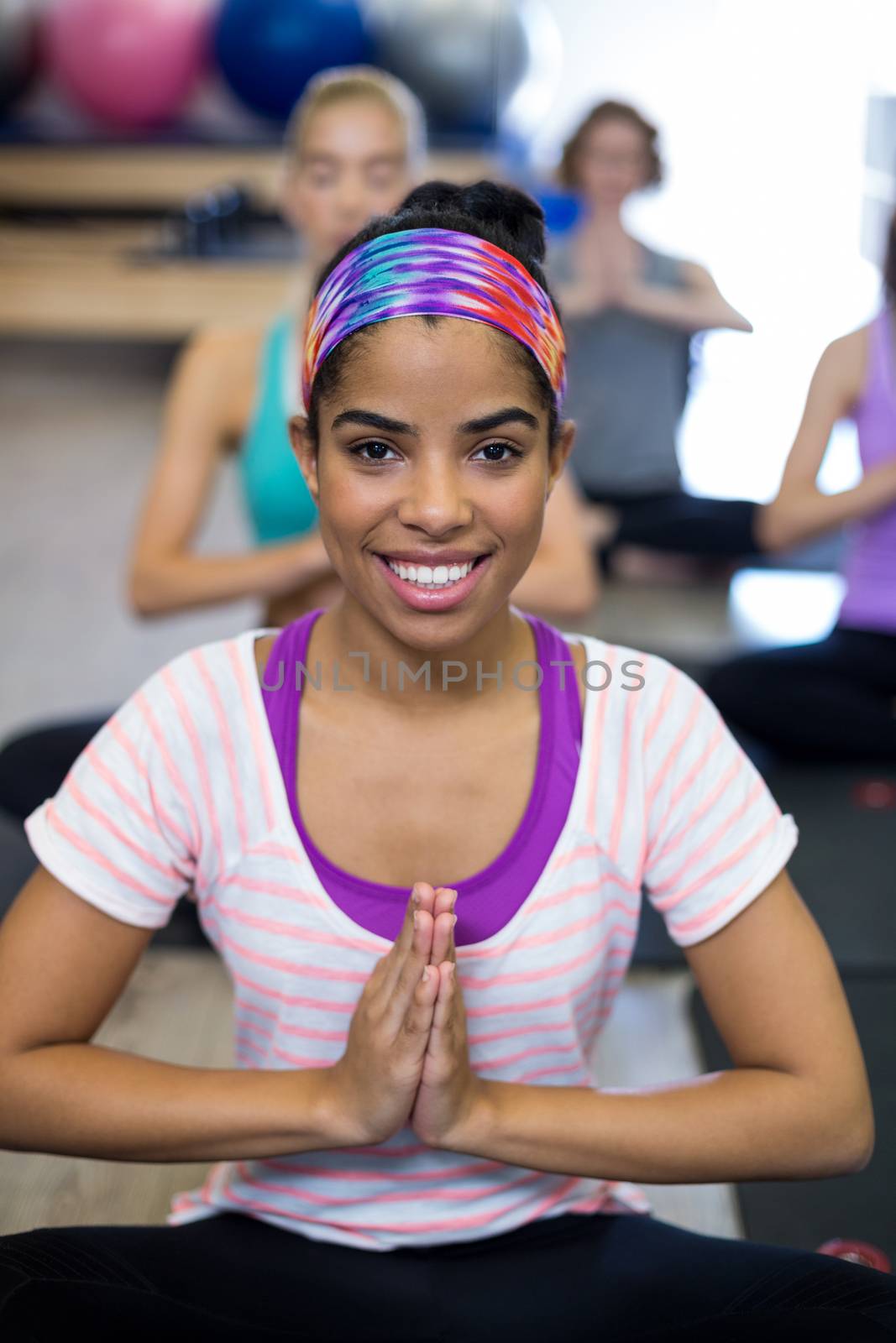 Smiling woman doing yoga in gym by Wavebreakmedia