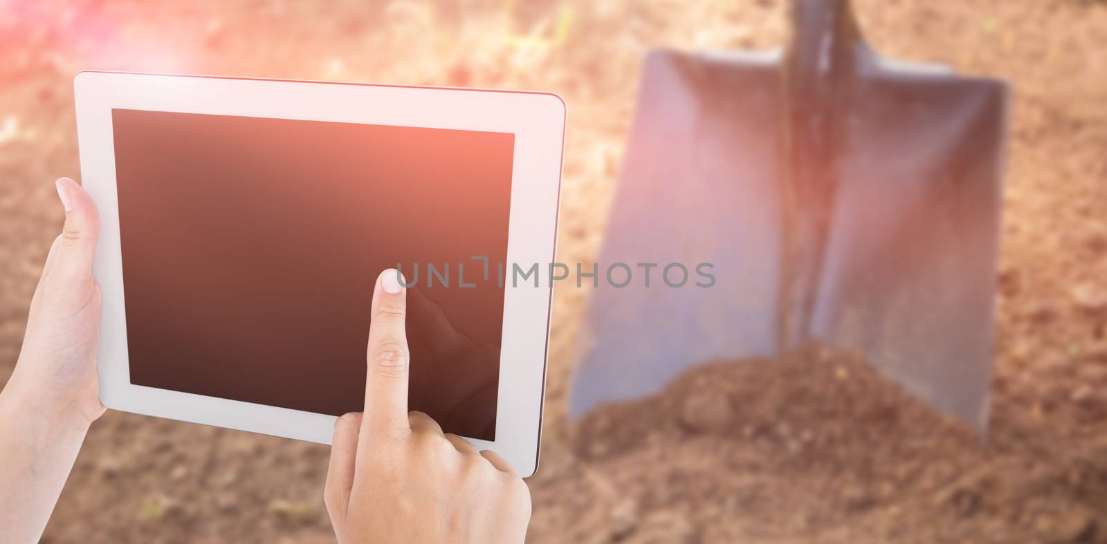 Woman using tablet pc against high angle view of shovel on dirt