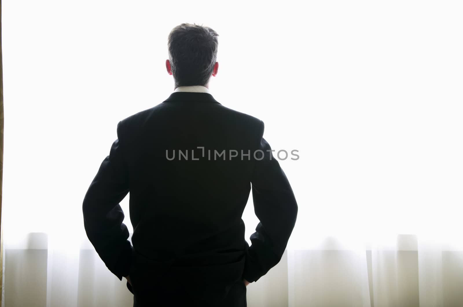 Caucasian businessman in contemplation looking out of a window themes contemplation unrecognisable stress