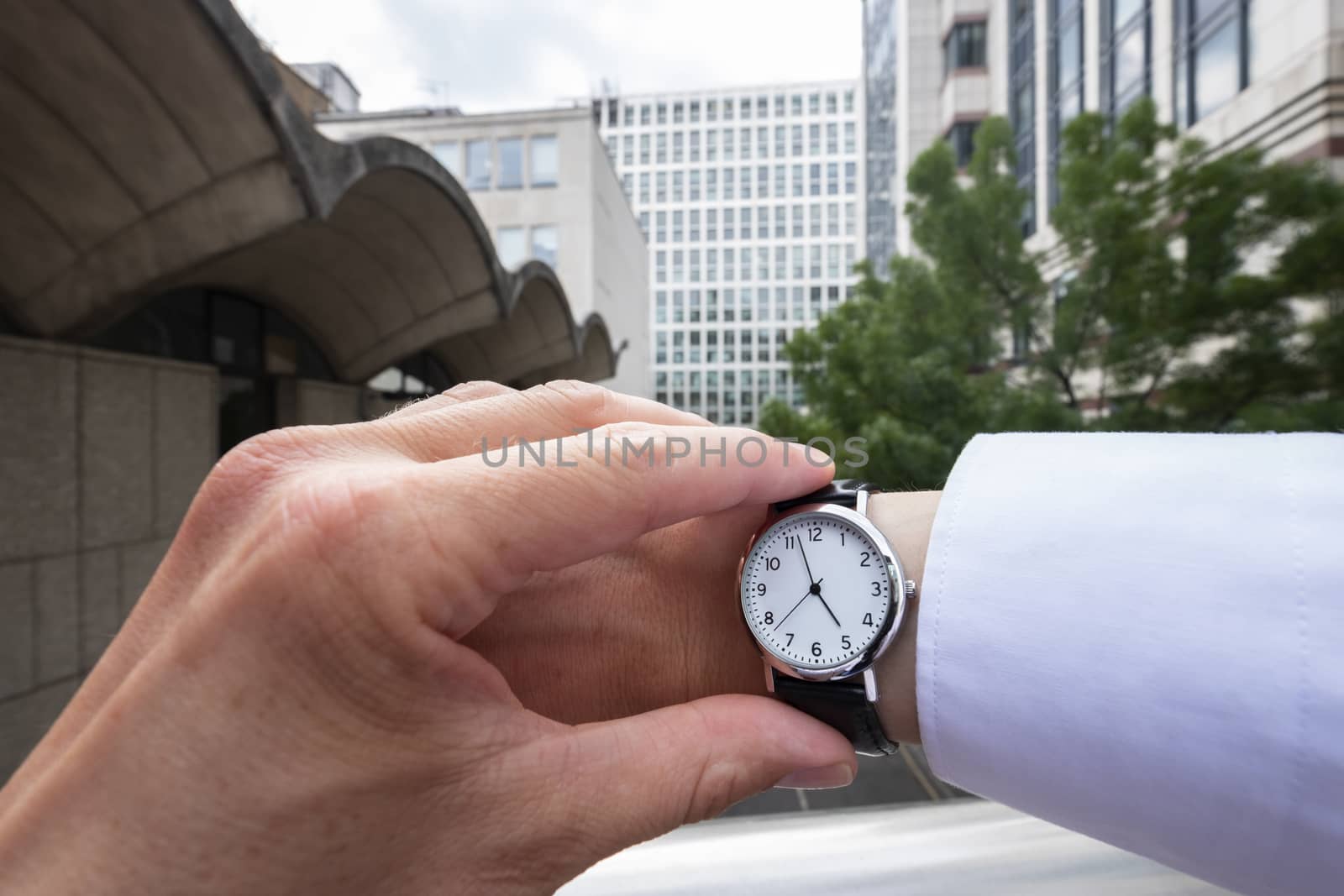 Personal perspective of a caucasian businessman looking at his wristwatch themes of deadlines departure late