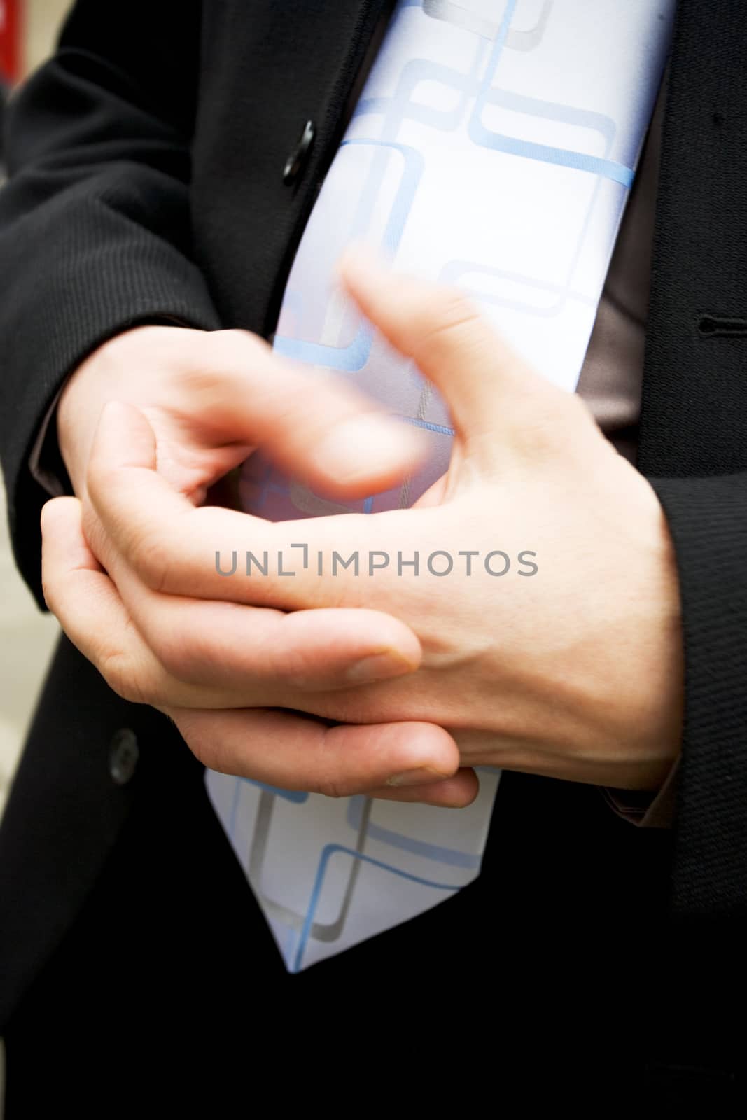 Businessman twiddling his thumbs themes of impatience boredom