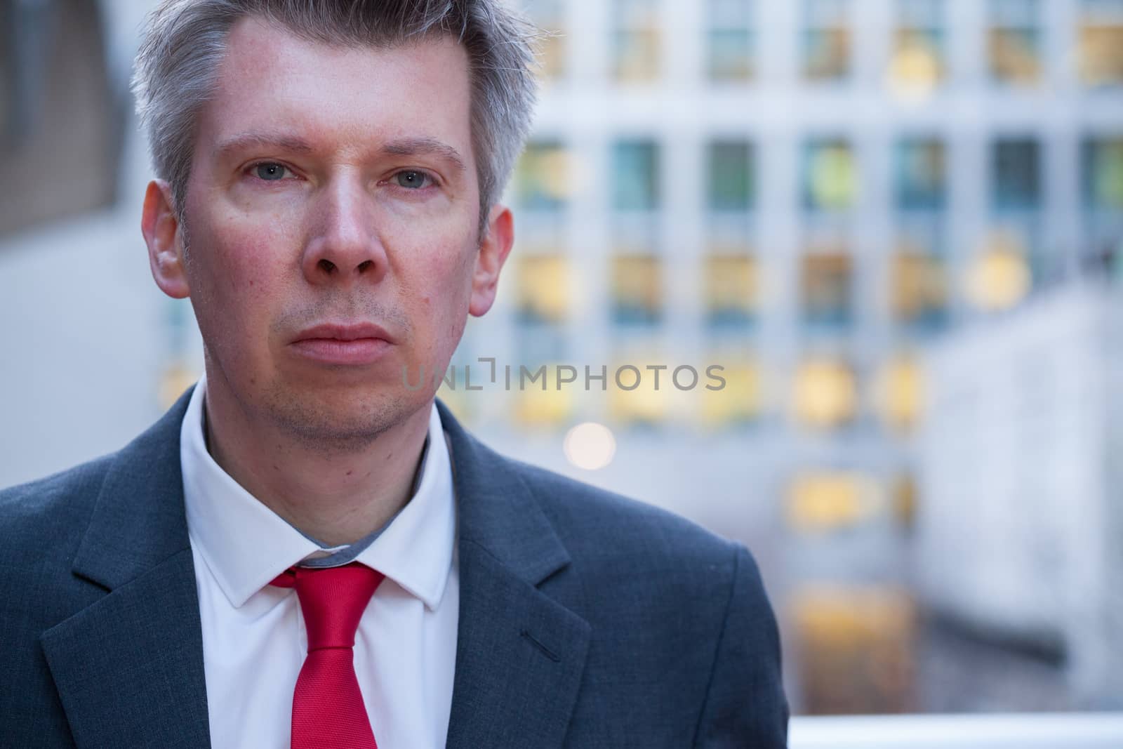 Businessman looking at the camera at dusk themes of departure leaving deadlines rush hour