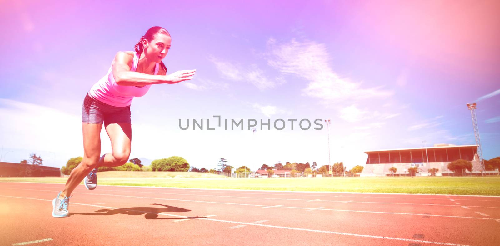 Female athlete running on running track on sunny day