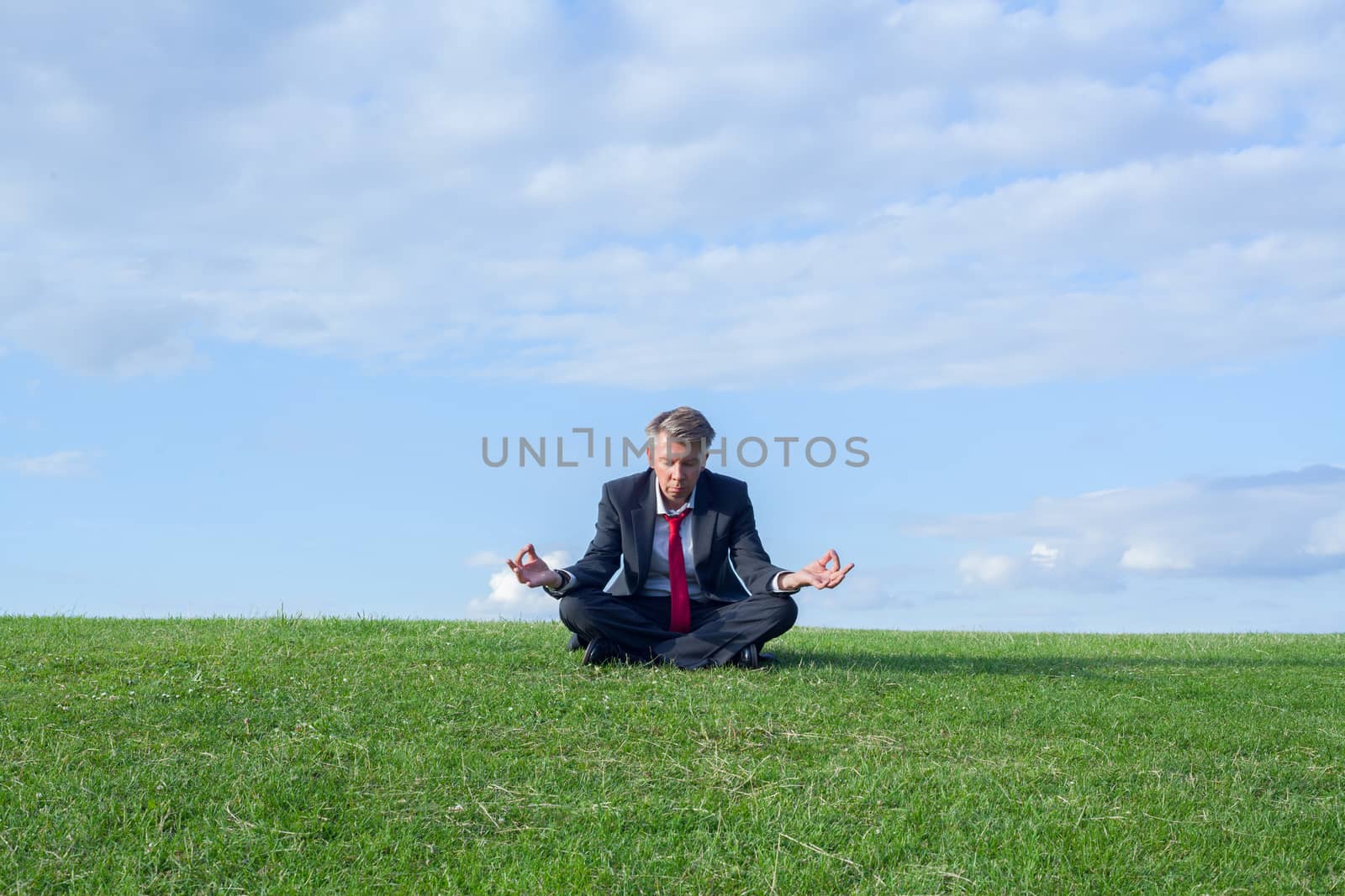 Businessman practicing yoga in the lotus position themes of wellness yoga escapism