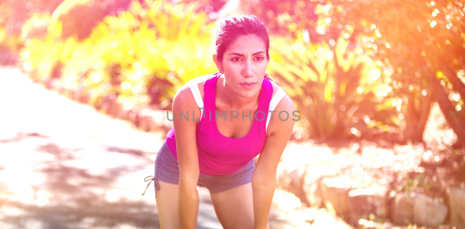 Tired beautiful woman taking break while jogging in park