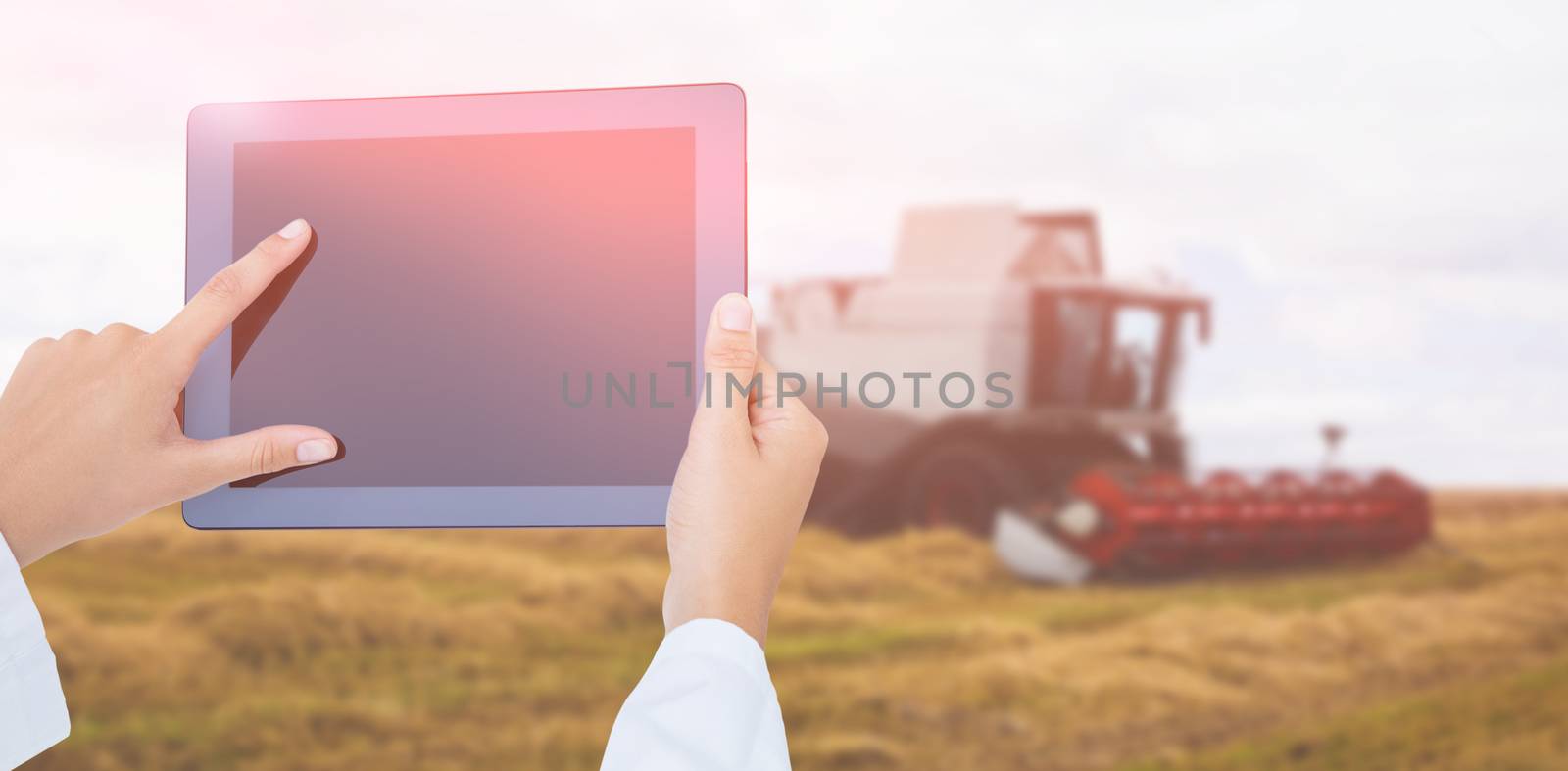Doctor using tablet pc against view of a harvester