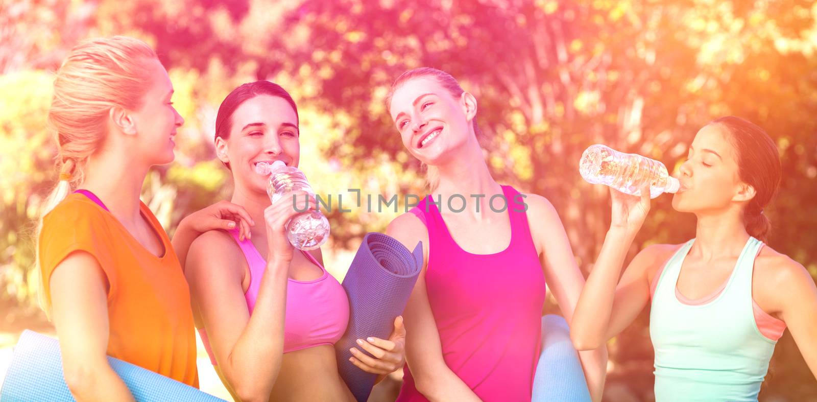 Beautiful women holding exercise mat after workout in park