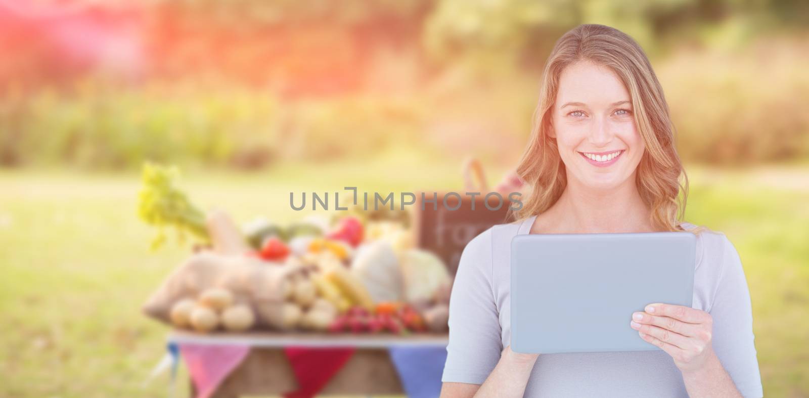 Portrait of happy woman holding digital tablet against food with slate on table