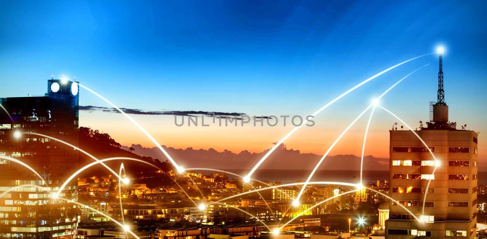 Illuminated buildings in city against sky at dusk