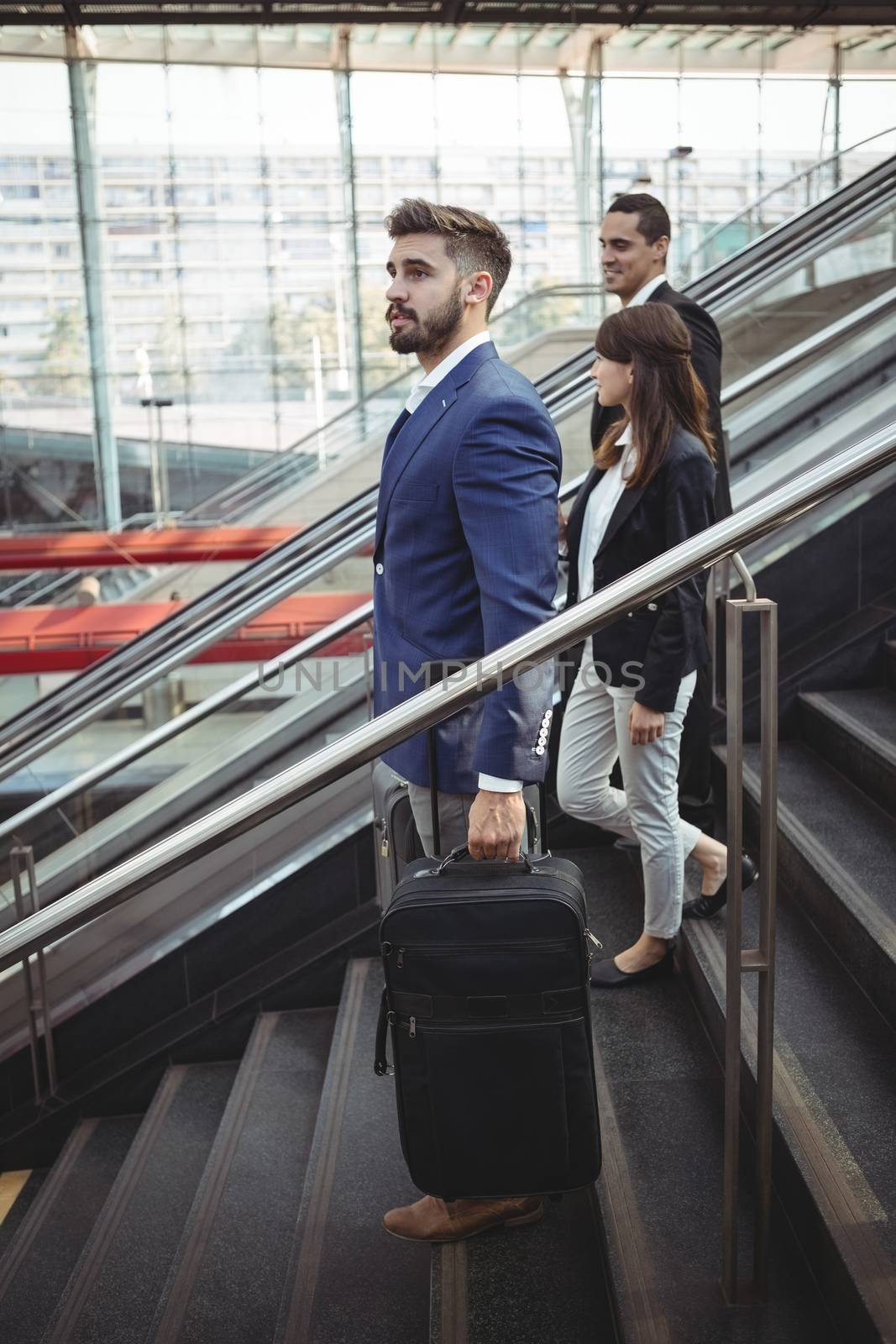 Smiling business executives walking on stairs outside platform